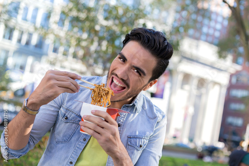 Man eating take away noodles in New York