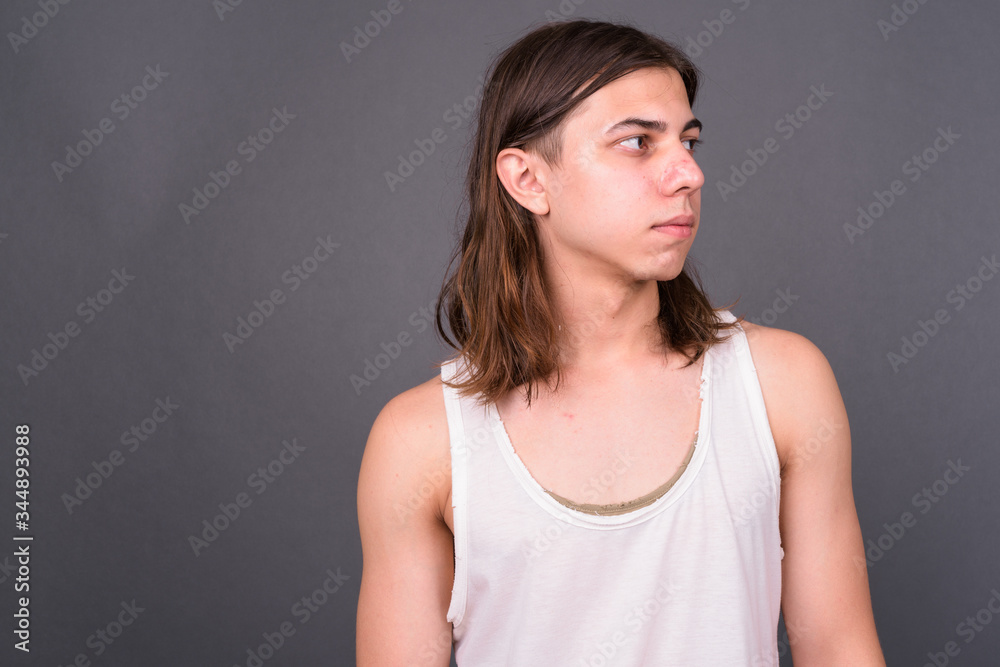 Young handsome androgynous man with long hair