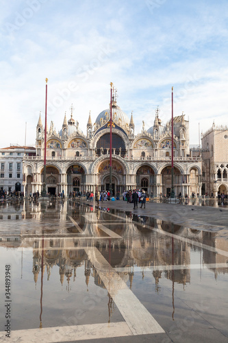 Basilica San Marco reflected in Acqua Alta high tide in Piazza San Marco, Venice, Italy