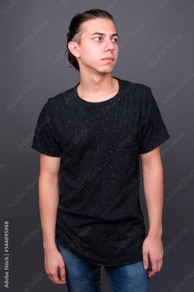Obraz premium Young handsome man with hair tied thinking and looking away