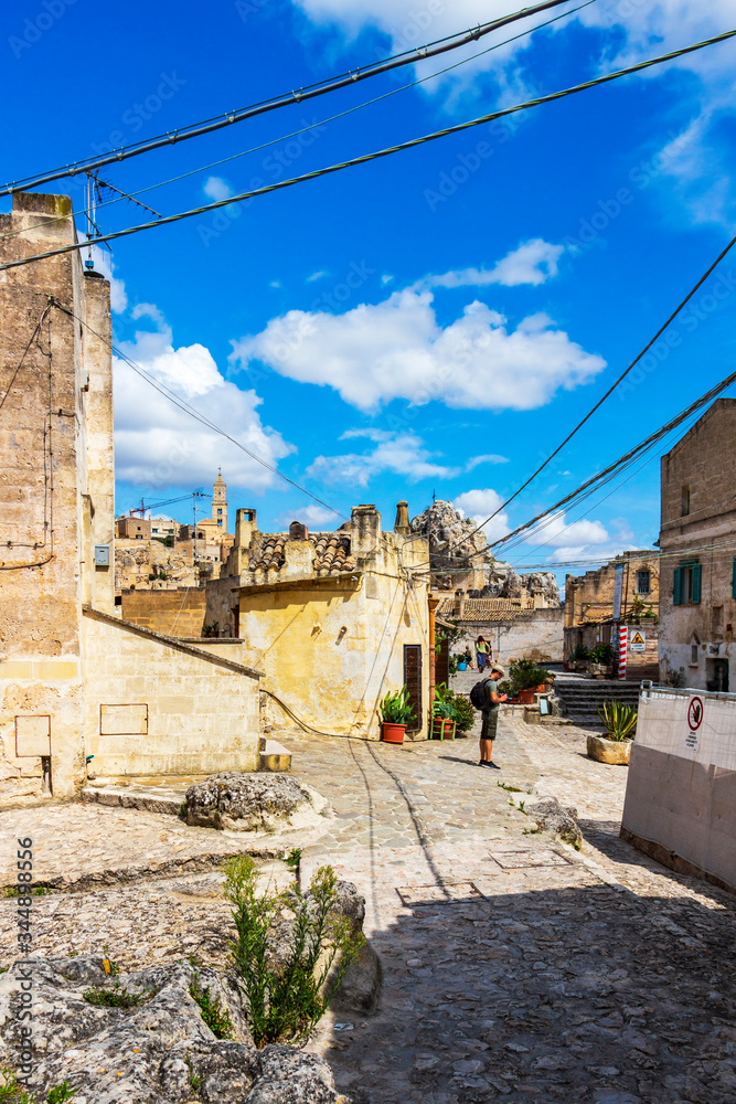 Obraz premium Sassi di Matera sunny summer street view with a male tourist in Matera, Province of Matera, Basilicata Region, Italy