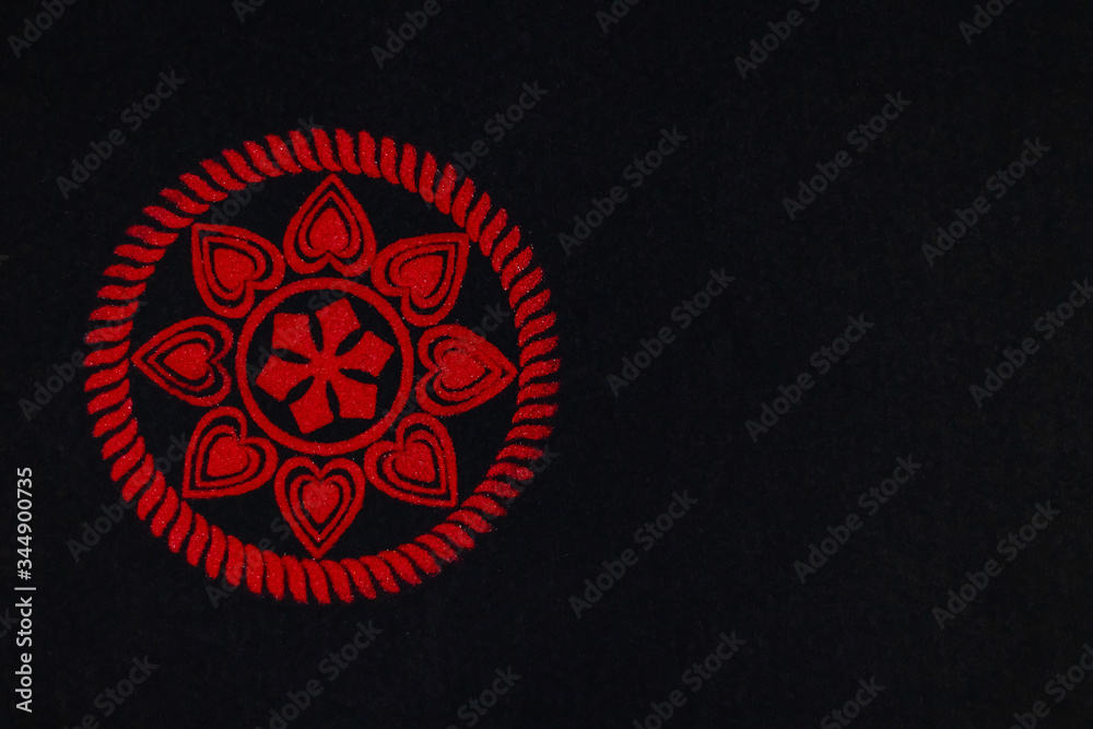 top view of beauitful floral rangoli made by red kumkum on black background with copy space. diwali concept top view of beauitful floral rangoli made by red kumkum on black background with copy space. diwali concept