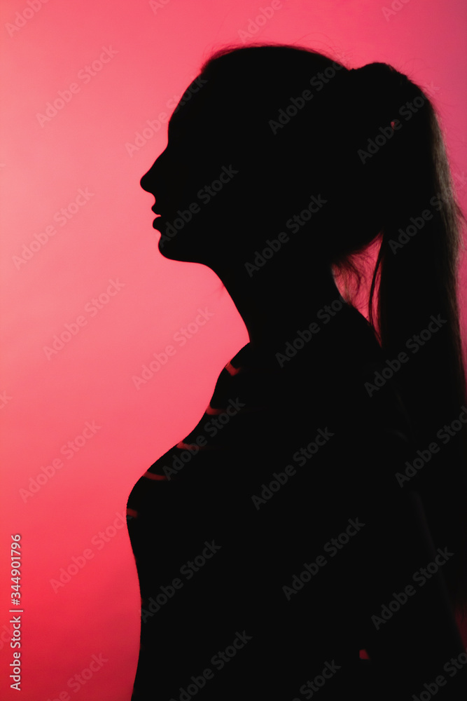 silhouette of thoughtful girl on red lightened background, unrecognizable woman face profile, concept emotions, stress