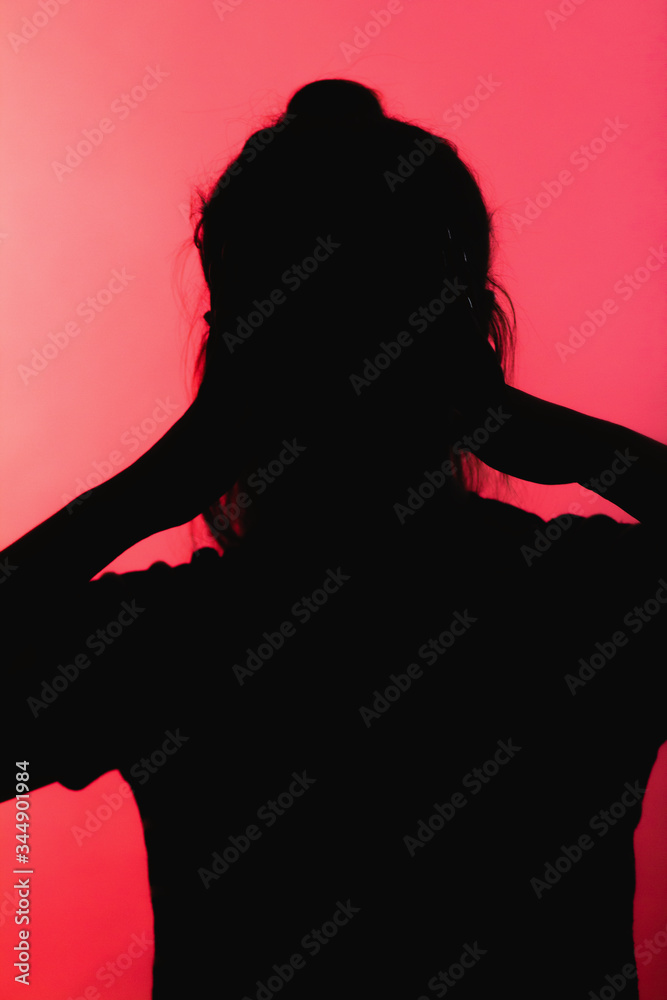 silhouette of worried girl clutched hands behind head in panic, unrecognizable woman on red background, concept life problems, stress,destructive emotions