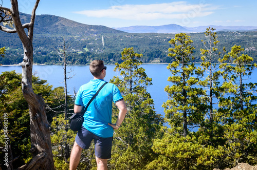 Fotografia Person from back looking at the immensity of a mountain landscape with a lake at his feet