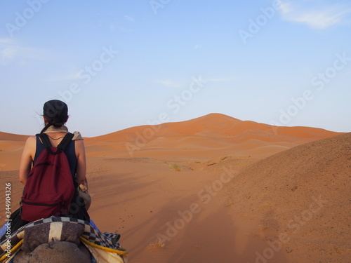 A woman rides camel in Sahara Desert, Merzouga, Morocco