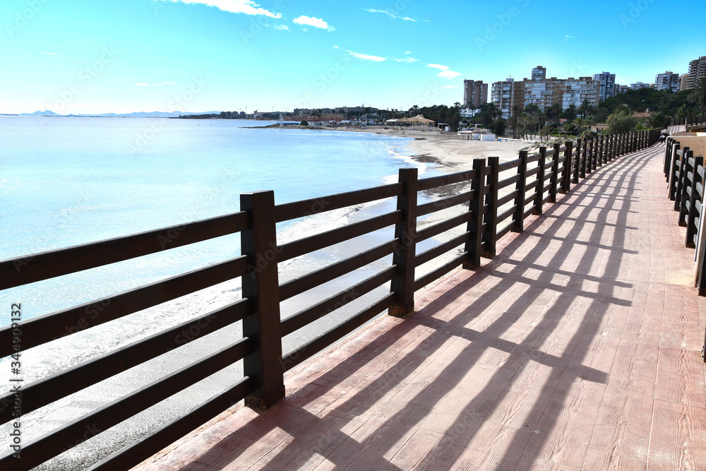 Mediterranean Sea coastal resting area in Campoamor, Alicante. Pedestrian path along the sea. Empty beaches during coronavirus quarantine