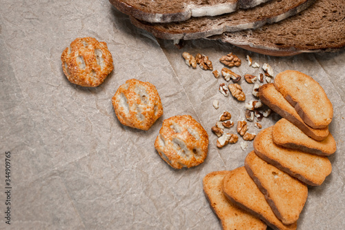 Baking, dark bread, cookies and rolls on a dark background.
Kraft paper. Milk in a transparent glass.