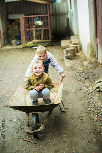children rides on a wheelbarrow © vandame