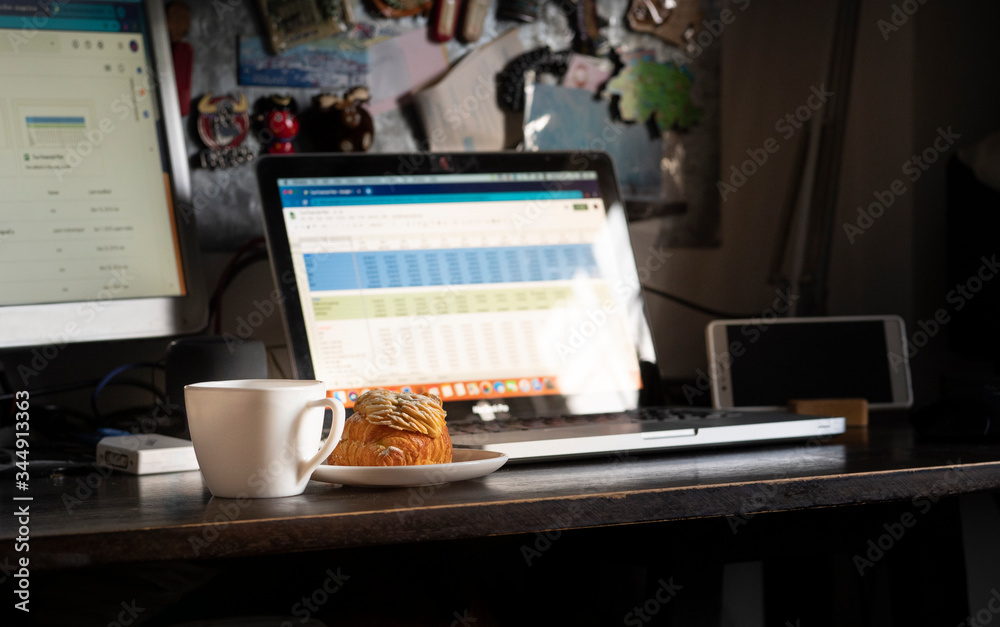 enjoy with fresh and delicious almonds croissant with coffee and ready to work at home. Focus at croissant. enjoy with fresh and delicious almonds croissant with coffee and ready to work at home. Focus at croissant.