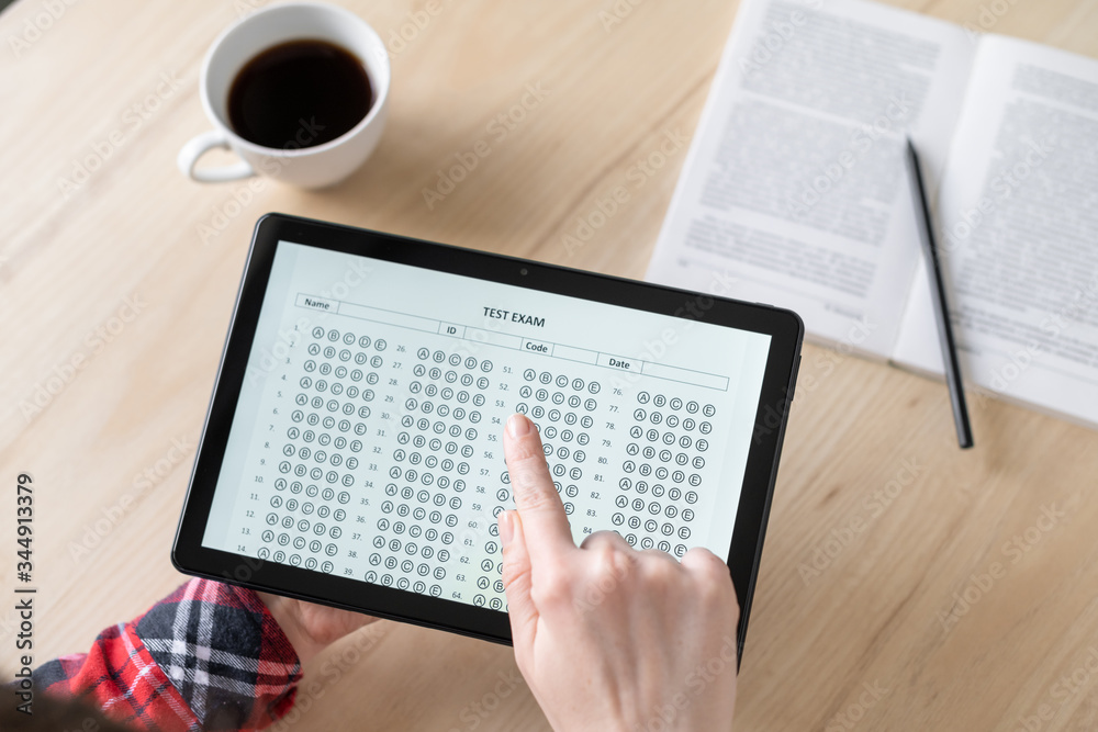 Obraz premium Online exam. Woman student testing exercise. Examination test on the tablet for school, university. multiple choice answer sheet. Home school, online study. Tutorial