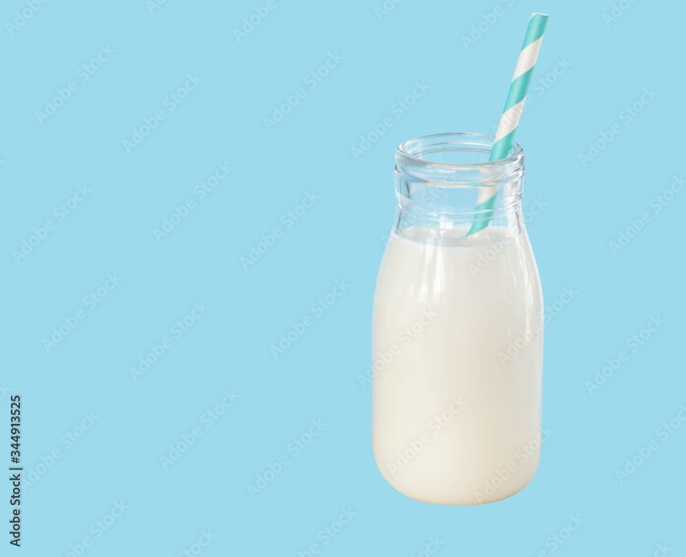 Bottle of fresh milk with straw on light blue background, food healthy concept Bottle of fresh milk with straw on light blue background, food healthy concept