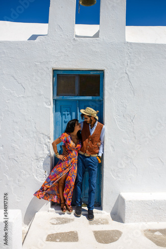 A man and a woman are posing in the streets of Imerovigli Village, on Santorini Island..He is an ethnic gypsy. She is an Israeli. © wolfhound911
