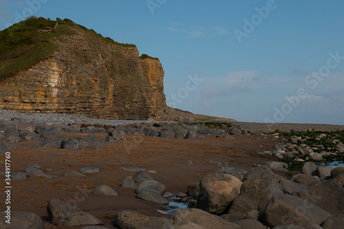 Llantwit Major Beach Vale of Glamorgan with Cliff Face and Rocks on the Beach in the Evening Light photo