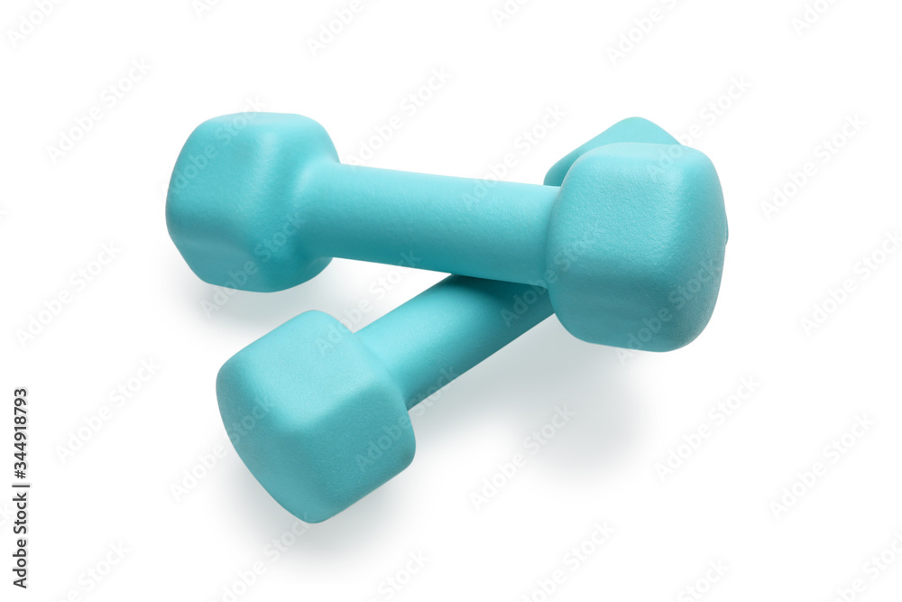 Two turquoise colored rubber dumbbells lying at white table Two turquoise colored rubber dumbbells lying at white table
