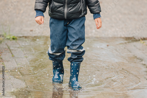 Junge mit Gummistiefel in eine Wasserpfütze