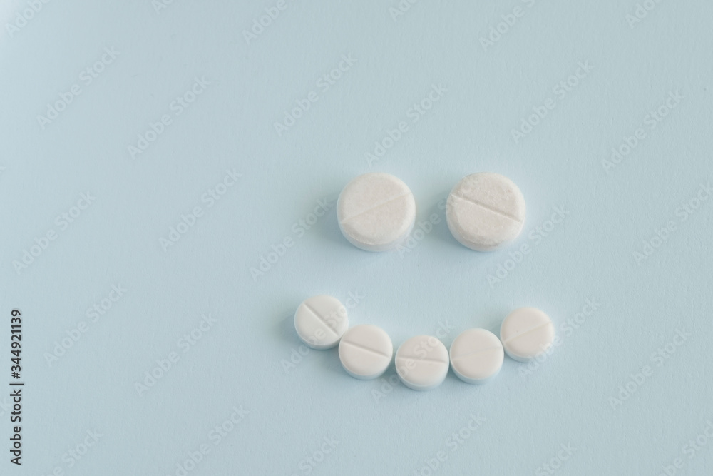 concept of good medicine. happy face made up of pills on blue backgroud