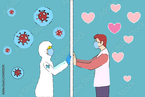 A woman doctor in personal protective equipment suit is looking to her husband through the cleanroom mirror that separates them.