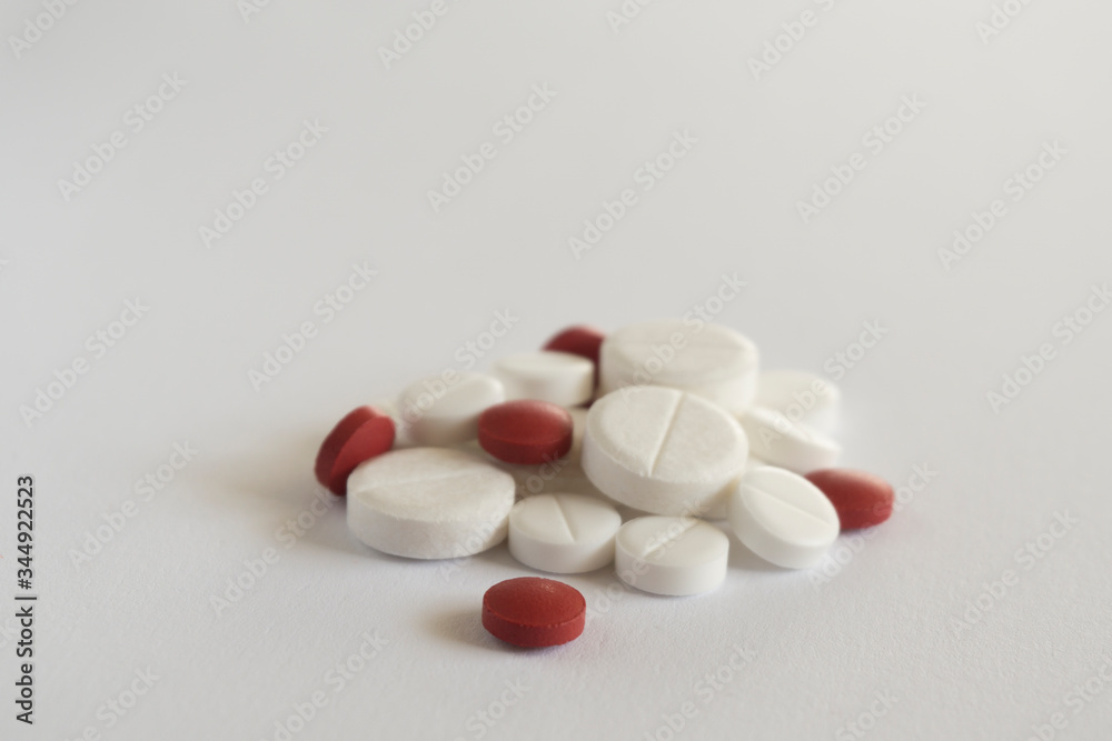 pile of red and white pills on blue background with copy space. medicine concept
