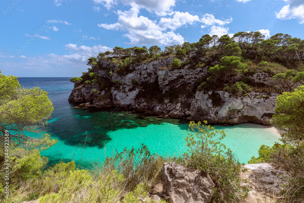 View of the beautiful little beach Cala Macarelleta with clear emerald water of the island Menorca, Balearic islands, Spain