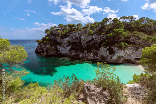 View of the beautiful little beach Cala Macarelleta with clear emerald water of the island Menorca, Balearic islands, Spain