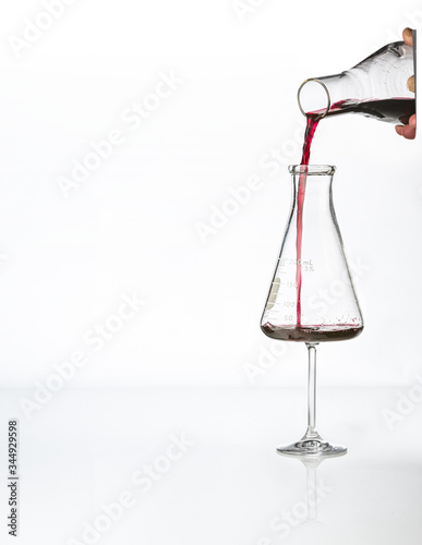 red wine pouring into lab beaker