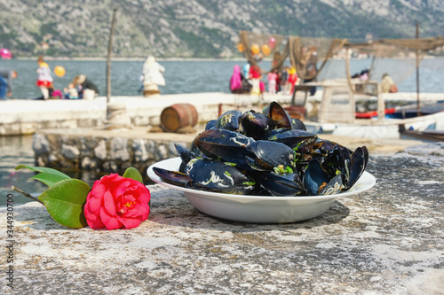  Local holidays of Montenegro. Camellia festival in Stoliv town. Camellia flower and  dish with mussels - symbols of this spring holiday photo