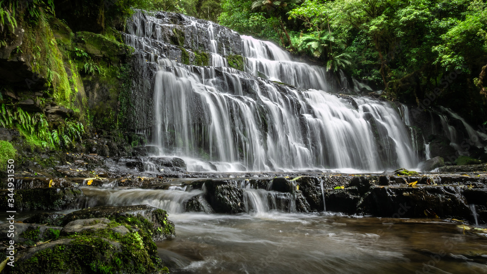 Beautiful cascade waterfall surrounded by forest. Shot made at Purakanui Falls in Catlins Forest Park, New Zealand