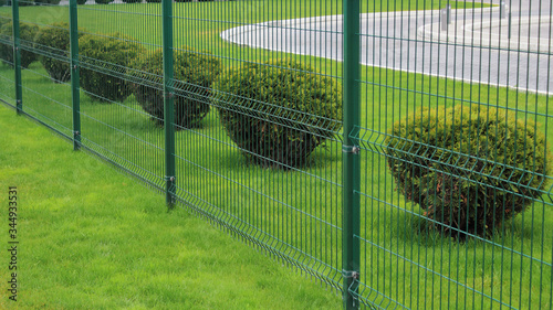 neat fence and bushes of the park area in the city