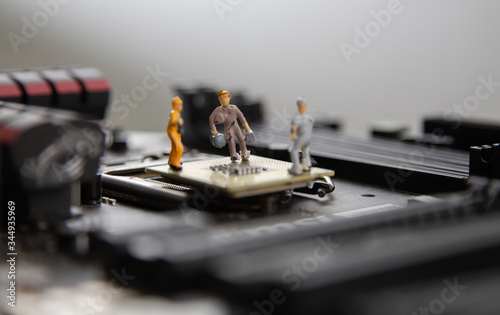 miniature people Motherboard and CPU repair, Concept: working in technical teams, technology systems Behind the maintenance engineering, Computer Hardware for memory, closeup mini top view