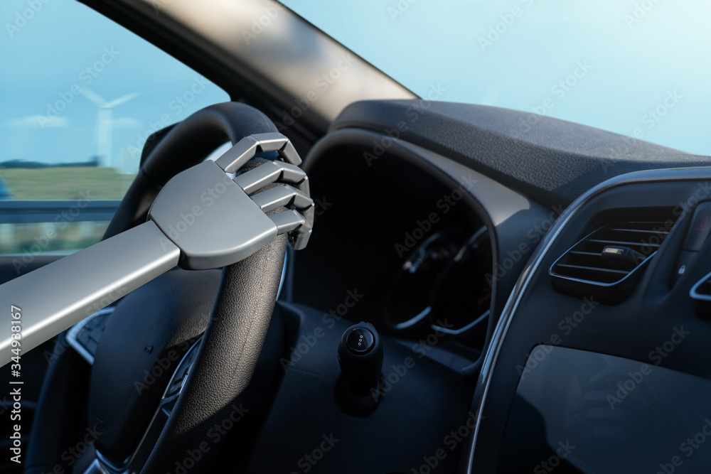 Robot arm on a steering wheel. Artificial intelligence drives a car. Autonomous vehicle concept.
