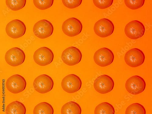 Colorful fruit pattern of fresh mandarins on an orange background. Top view