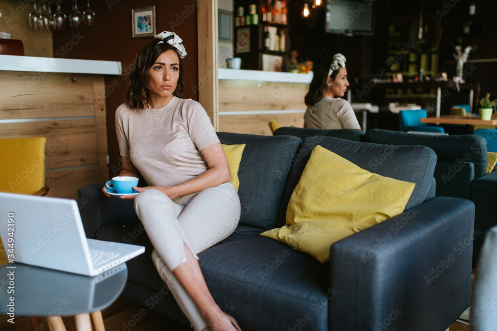 Attractive young caucasian woman drinking coffee and working on laptop. Business and pleasure Attractive young caucasian woman drinking coffee and working on laptop. Business and pleasure
