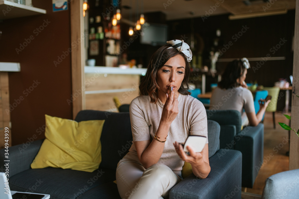 Fototapeta premium Pretty young caucasian woman makeup in a cafe