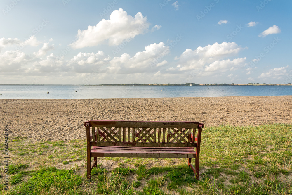 Lonely bench facing beautiful beach at the Baltic Sea in Northern Germany