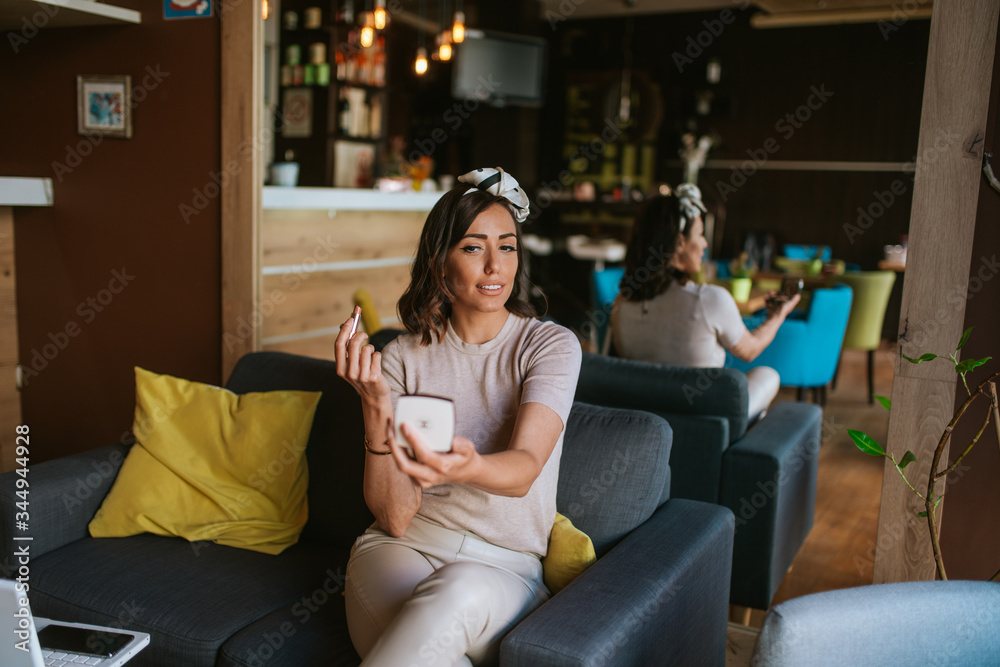 Pretty young caucasian woman makeup in a cafe Pretty young caucasian woman makeup in a cafe