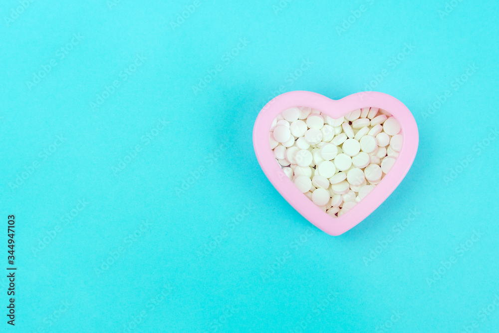 Full of white pills the pill box in heart shape, top view Full of white pills the pill box in heart shape, top view
