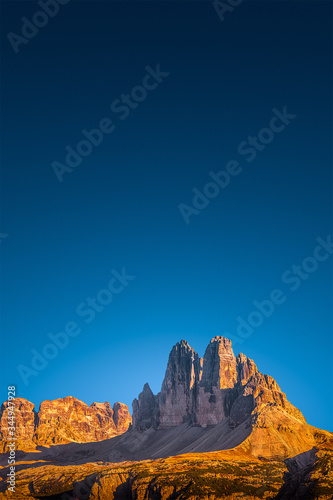 View over beautiful red sunset in magical Three Dolomite peaks at the national park Three Peaks  Tre Cime  Drei Zinnen  at blue sky  South Tyrol  Italy  cover page