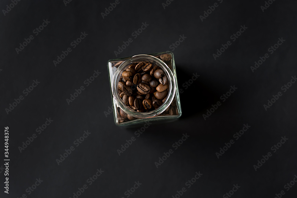 coffee beans in a glass jar on a black background coffee beans in a glass jar on a black background