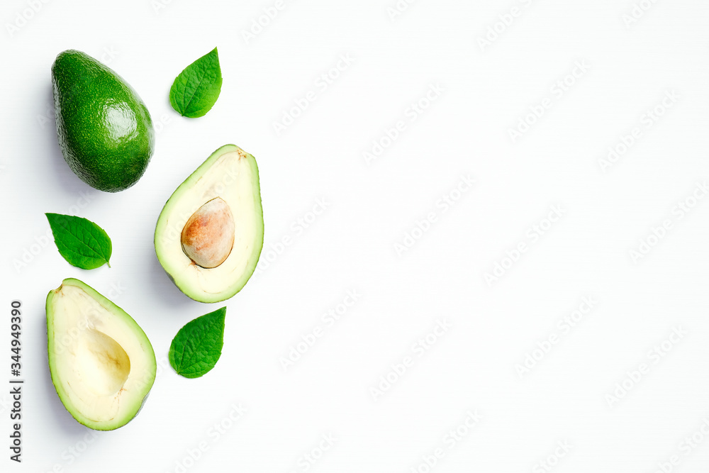 Fresh ripe avocado with green leaves on white background. Flat lay, top view, copy space. Fresh ripe avocado with green leaves on white background. Flat lay, top view, copy space.