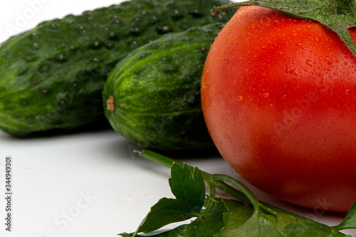 whole juicy bright red tomatoes with green cucumber isolated on a white background photo