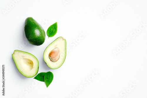 Avocado with green leaves on white background. Flat lay, top view, copy space.