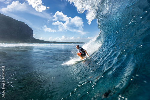 muscular surfer riding on big waves on the Indian Ocean island of Mauritius