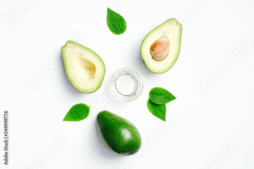 Fresh avocado and bowl with essential oil on white background. Flat lay, top view. SPA natural organic cosmetic product, hair care concept