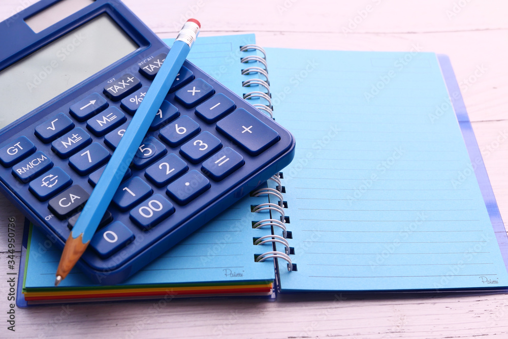 empty notepad with pencil and calculator wooden background 