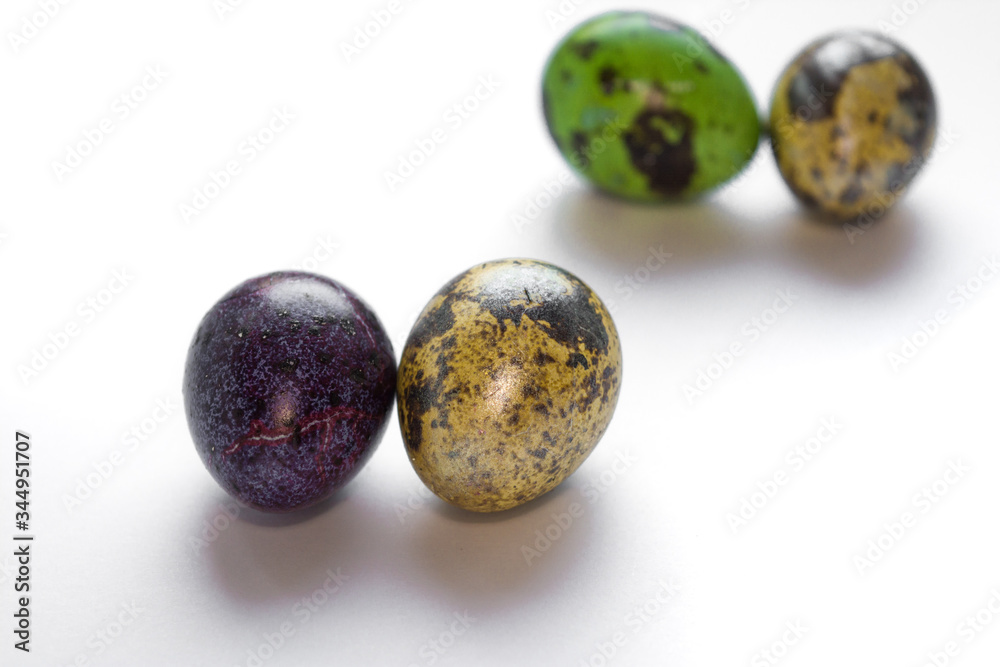 Easter multicolored quail spotted eggs lie on a white background Easter multicolored quail spotted eggs lie on a white background
