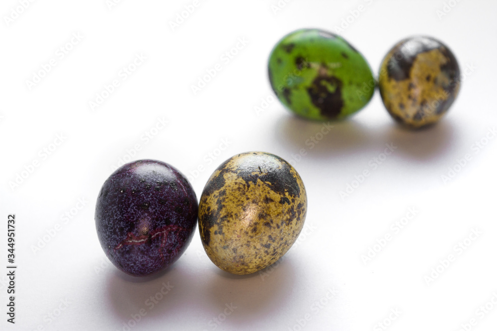 Easter multicolored quail spotted eggs lie on a white background Easter multicolored quail spotted eggs lie on a white background