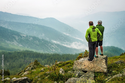 Tourists admire the mountain scenery. Foggy weather high in the mountains in summer