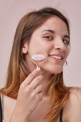 Young woman tries jade roller photo