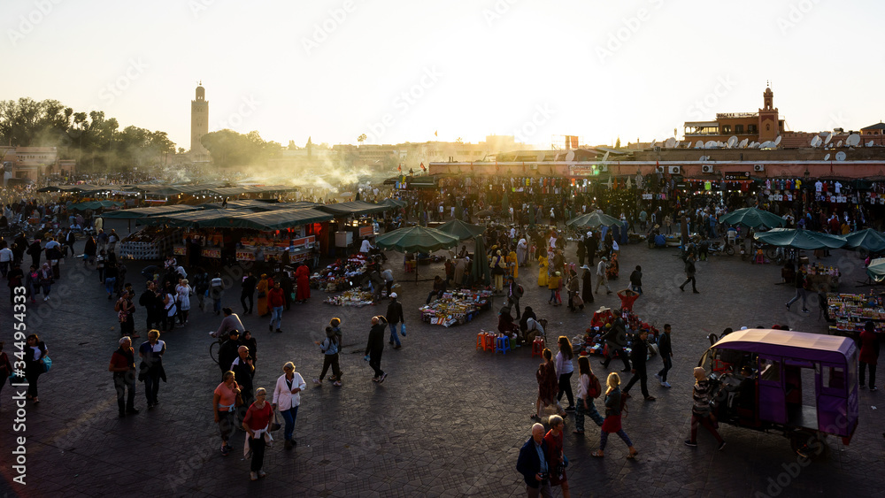 Marrakesh, Morocco - 04/05/2018: Tourists visiting Place Jemaa el Fna at sunset
